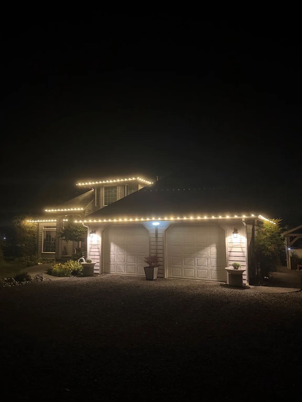 Sound Christmas warm-white C9 lights on a two-car garage and upper roofline